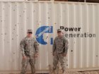 1LT Riley Emter and a fellow solider in front of a Cummins Generator in Iraq