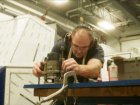 An SSL Craftsman carefully prepares an outer skin panel prior to fitting to the basic frame which can be seen behind him